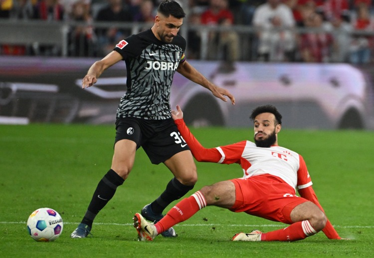 Vincenzo Grifo challenges Noussair Mazraoui with the ball during a Bundesliga match